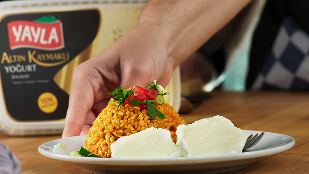 Food TVC of a bulgur recipe. The bulgur is served on a plate with yoghurt and some decorations. In the background we can see the product which was used for the recipe. 