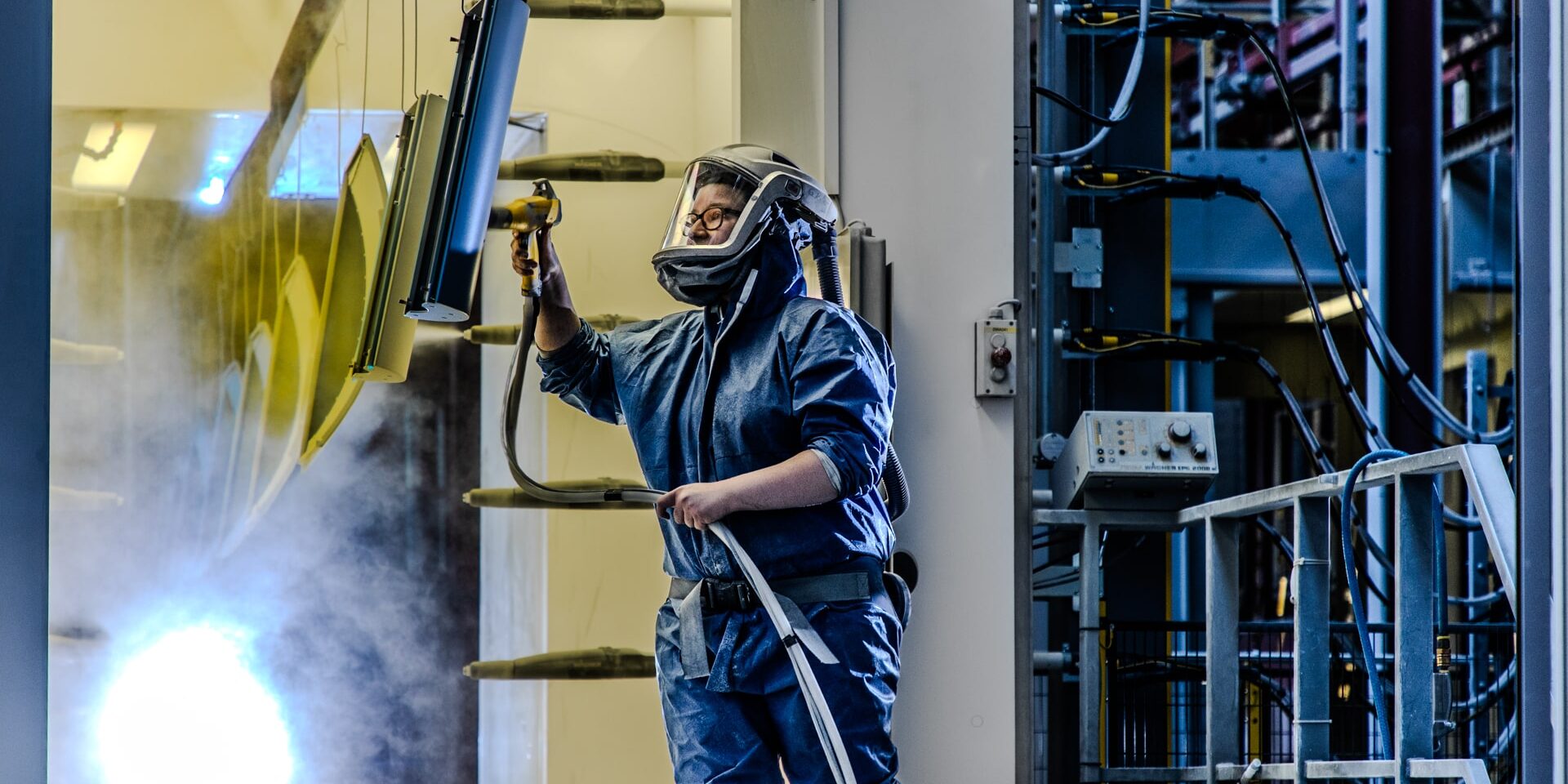 Unternehmensfotografie aus dem Imagefilm für die Deutsche Mechatronics, das einen Lackierer in der Fertigungshalle zeigt
