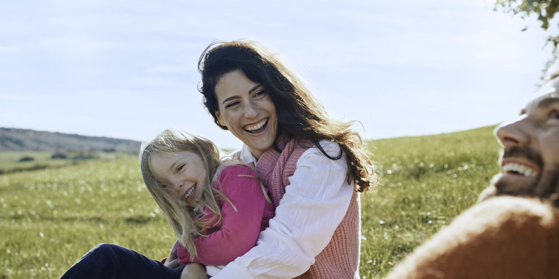 Imagefilm Standbild für die Marke F&#038;S concept Projektentwickler, auf dem eine Familie lachend in der Natur sitzt