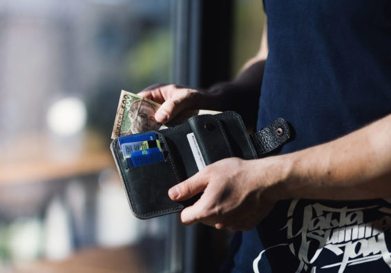 man holding a wallet with cash