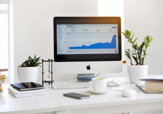 iMac standing on a table with statistics on the screen