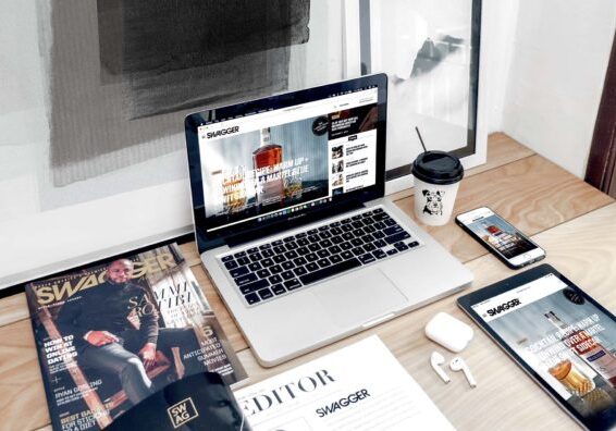 Schreibtisch mit verschiedenen Medien und Laptop