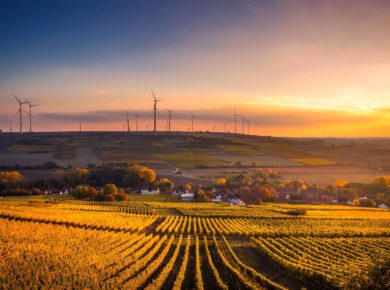 Ländliche Gegend im Sonnenuntergang mit Windrädern am Horizont