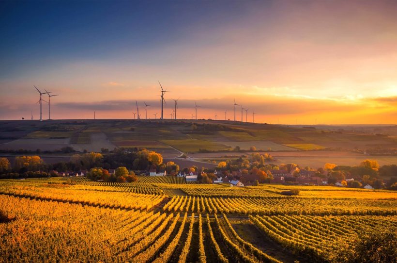 Ländliche Gegend im Sonnenuntergang mit Windrädern am Horizont