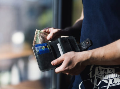 man holding a wallet with cash