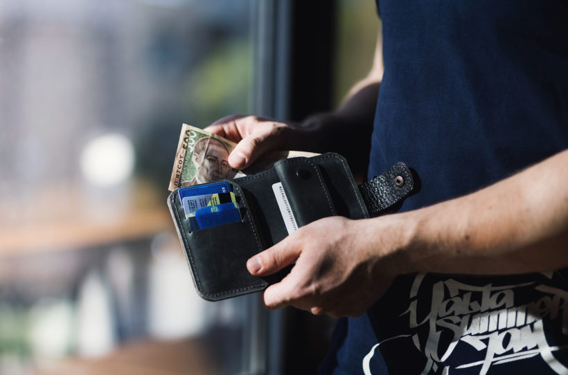 man holding a wallet with cash