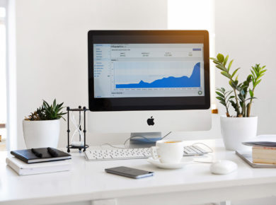 iMac standing on a table with statistics on the screen