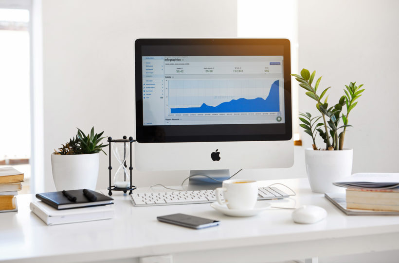 iMac standing on a table with statistics on the screen