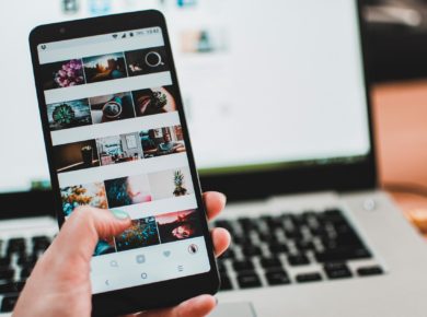 Smartphone mit Instagram Feed vor Laptop