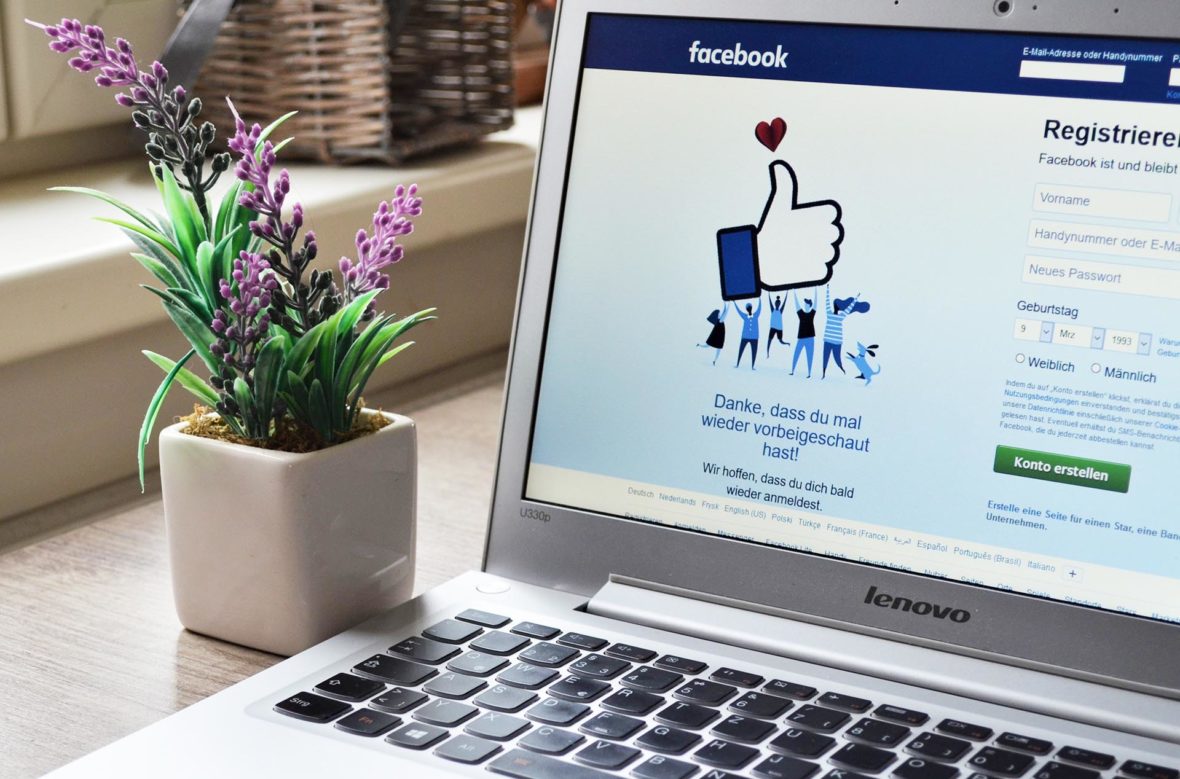 Laptop mit Social Media Facebook auf Schreibtisch mit Lavendel